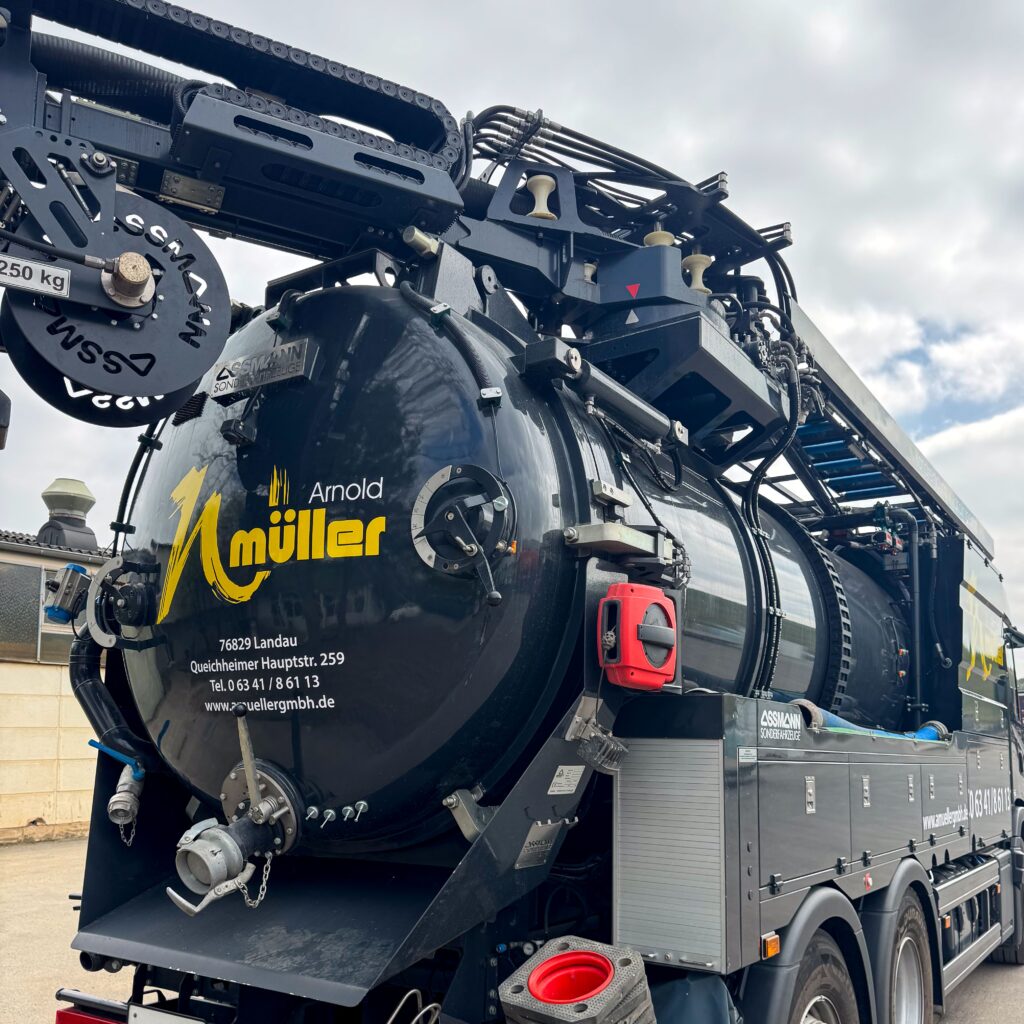 Detailaufnahme des hochmodernen Kanalreinigungsfahrzeugs der Arnold Müller GmbH. Sichtbar sind technische Komponenten und das Firmenlogo.