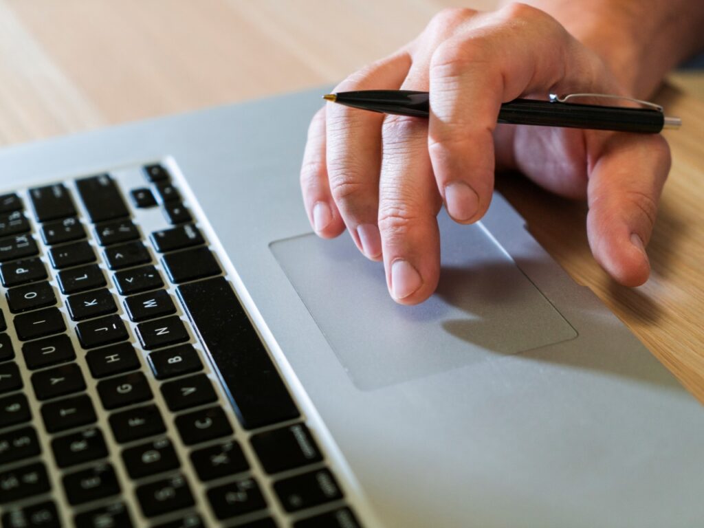 Finger bewegen sich über Touchpad eines Laptops