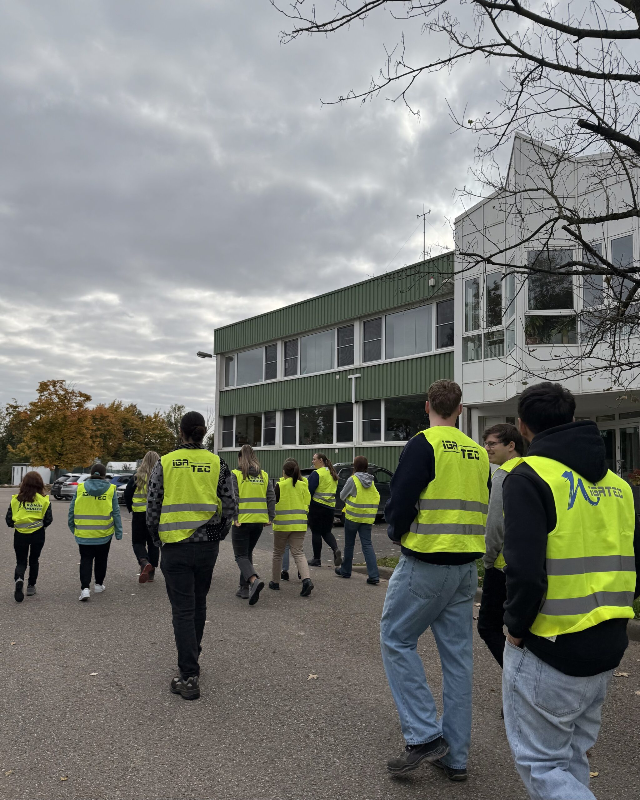 Gruppe von Azubis in Warnwesten laufen über das Gelände der WILLERSINN Gruppe